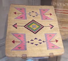 an old rug is sitting on display in a glass case with other items behind it