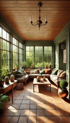 a sun room filled with lots of windows and furniture next to plants on the floor