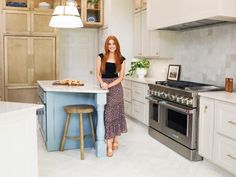 a woman standing in a kitchen next to an island