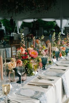 a long table is set with flowers and candles for an elegant dinner party or reception