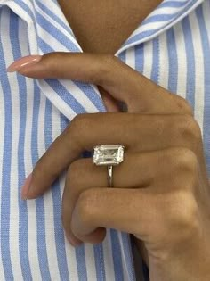 a close up of a person wearing a ring with a baguette on it