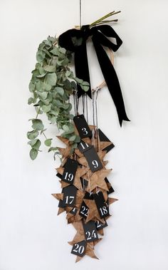 a black and white clock hanging from the side of a wall next to a plant