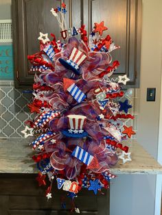 a patriotic wreath with red, white and blue decorations on it in front of a door