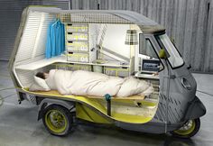 a man is sleeping in the back of a small truck with its bed attached to it