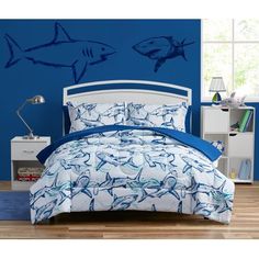 a bed room with a neatly made bed and a shark wall decal on the wall