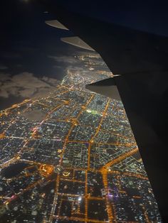 an airplane wing flying over a city at night