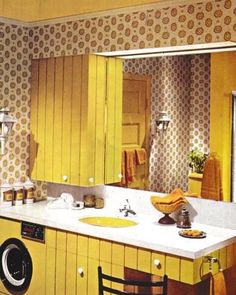 a washer and dryer in a room with yellow wallpaper on the walls