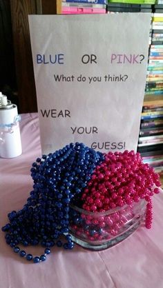 a bowl filled with beads next to a sign that says blue or pink? what do you think? wear your guessi