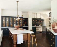 a large kitchen with wooden floors and black cabinets