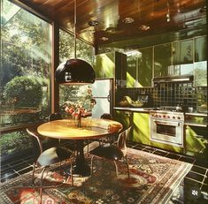 a kitchen with a table and chairs in front of a window that looks out onto the woods