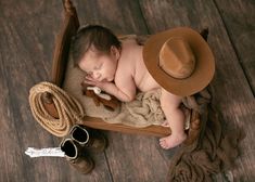 a baby sleeping in a wooden rocking chair with a hat on it's head