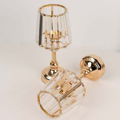 a glass and brass table lamp on a white surface with a light bulb attached to it