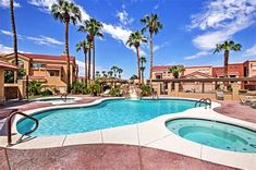 an outdoor swimming pool surrounded by palm trees