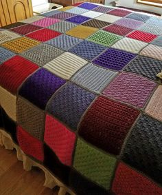 a bed with a multicolored blanket on top of it