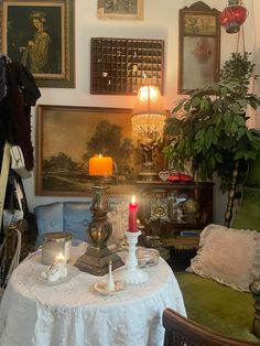 a living room filled with lots of furniture and pictures on the wall next to a table