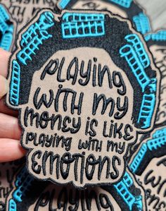 someone holding up a patch that says playing with my money is like pushing with my emotions