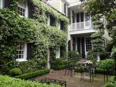 the front cover of an article about landscape architecture and garden design, with green ivy covered buildings in the background