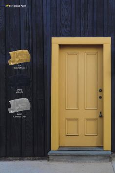 a yellow door and some paint colors on the side of a black building with wooden slats