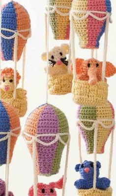 crocheted hot air balloons are hanging from the ceiling and have animals on them