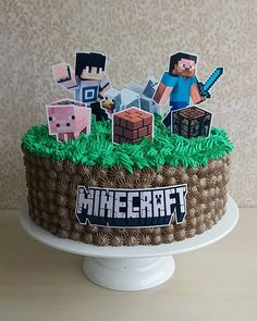 a cake that is decorated to look like minecraft with paper cutouts on top