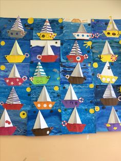 an art project made with construction paper and boats on the wall in front of a blue background