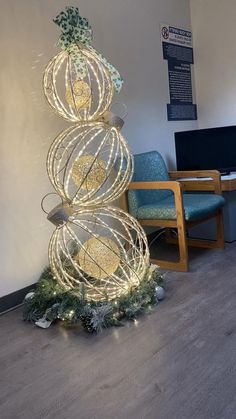 an office decorated for christmas with lights and ornaments on the floor, along with two blue chairs