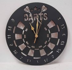 a black clock with darts on the face