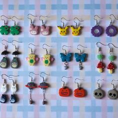 a bunch of earrings that are sitting on a checkered tablecloth with different designs