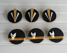 four black and gold decorated buttons on a wall