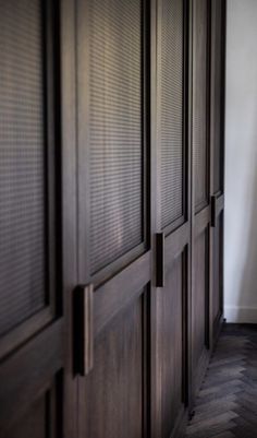 an empty room with wooden doors and hard wood flooring