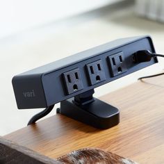 a black power strip sitting on top of a wooden table