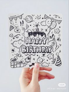 someone holding up a happy birthday card with doodles on the front and back of it