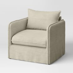 a beige chair with a white pillow on the back and arms, in front of a gray background