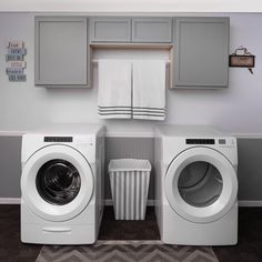 a washer and dryer sitting next to each other in a room with gray cabinets