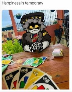 a cat sitting on top of a table next to playing cards