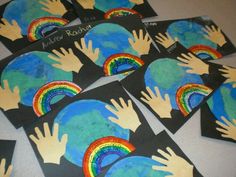 children's hands and rainbows on black paper