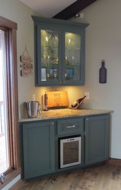 a kitchen with green cabinets and wooden floors