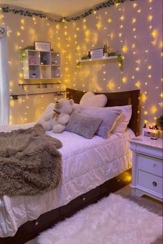 a bedroom decorated in white with lights on the walls and fur rugs around the bed