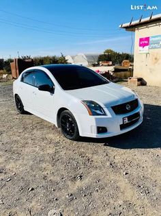 a white car is parked in the dirt