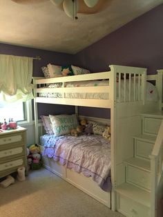 there is a bunk bed in the room with purple walls and white stairs to the second floor