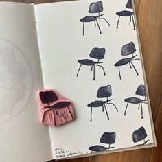 an open book with some drawings on the pages and a pink object sitting in front of it