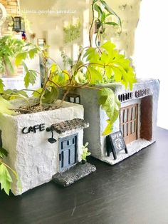 there is a small house made out of cement blocks with plants growing in the windowsill