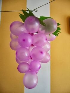 a bunch of pink balloons hanging from a line on a yellow and white striped wall