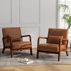 two brown leather chairs sitting next to each other on top of a carpeted floor