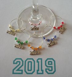 a wine glass filled with lots of different colored beads next to the word 2013 on it