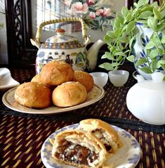 there is a plate with some pastries on it and a tea pot in the background