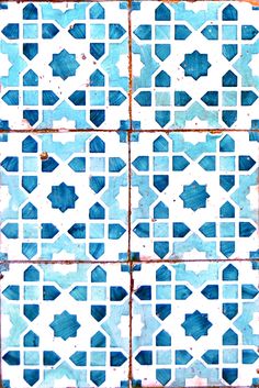 an old tiled wall with blue and white tiles on the bottom, in different shapes