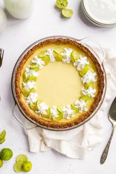 a pie with whipped cream and pistachios on top, surrounded by other dessert items