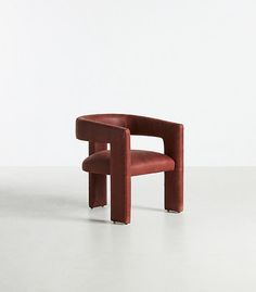 a red chair sitting on top of a white floor next to a wall in the background