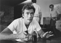 a man sitting at a table in front of a bottle